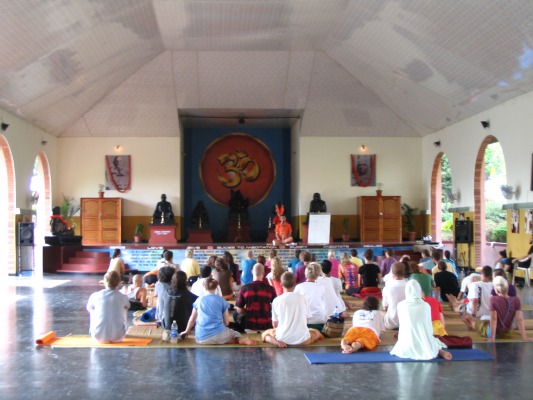 The swami (in orange on the stage) giving a lecture.